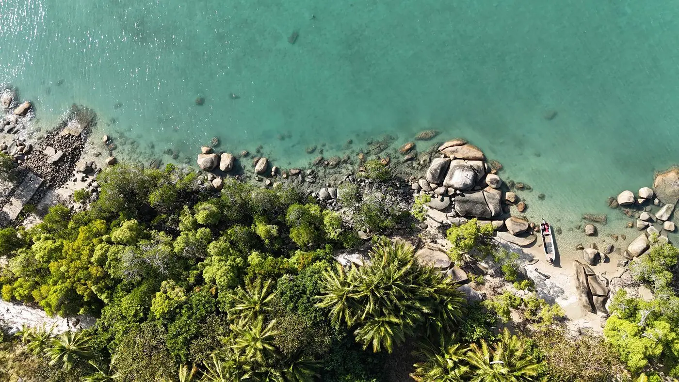 Aerial view of a rocky, forested Torres Strait coastline